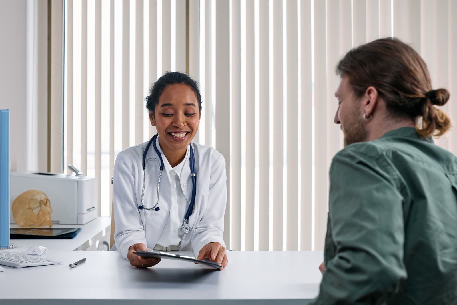 A doctor talking a male patient through his options in a bright clinic